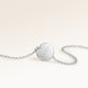 Back of a round silver necklace with a personal engraved date