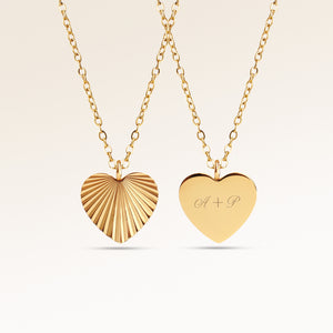 Heart-shaped gold necklace with ribbed sunburst pattern on front and personalized engraving of initials 'A + P' on back, from Mon Chou.