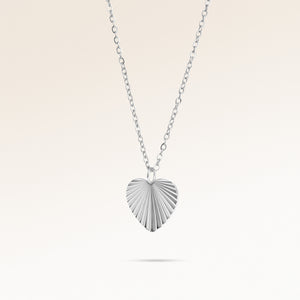 Heart-shaped silver necklace with ribbed sunburst pattern side view, space for engraving on back